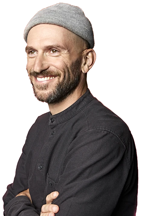 Portrait of Bastian Boss, smiling, arms crossed, wearing a grey beanie